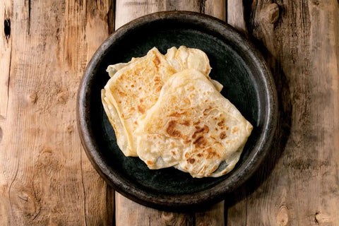 Guyanese Rotis placedin a wooden plate on a table.