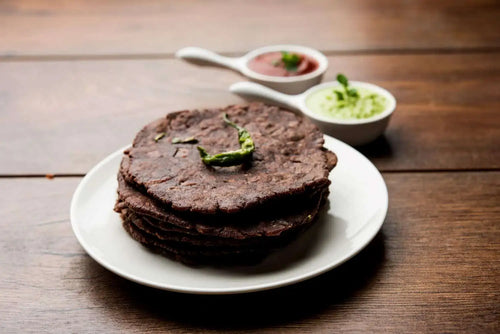 Ragi Roti in a plate with chutney in the bowl placed in a wooden table