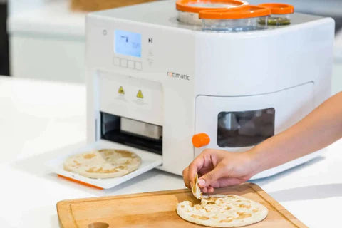 A person using a roti maker to make roti