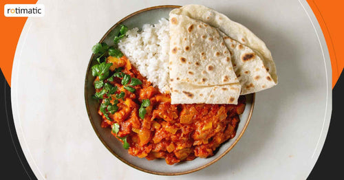 A plate of food with rice, curry and a piece of bread.